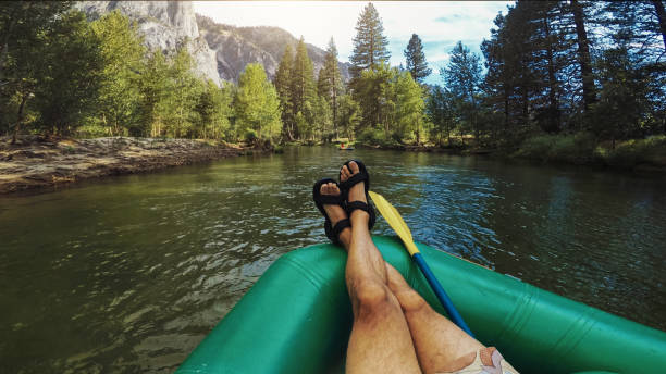 istock POV man relaxing while rafting in Merced River of Yosemite 1386173837