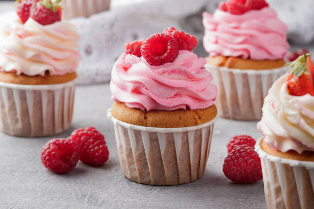 istock Pink cupcakes with cream and fresh berries 1386177842