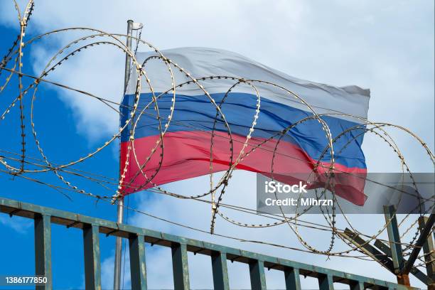 Russian Flag Behind Barbed Wire Against Cloudy Sky Stock Photo - Download Image Now - Russia, Authority, Prison