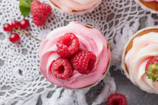 istock Pink cupcakes with cream and fresh berries 1386178136