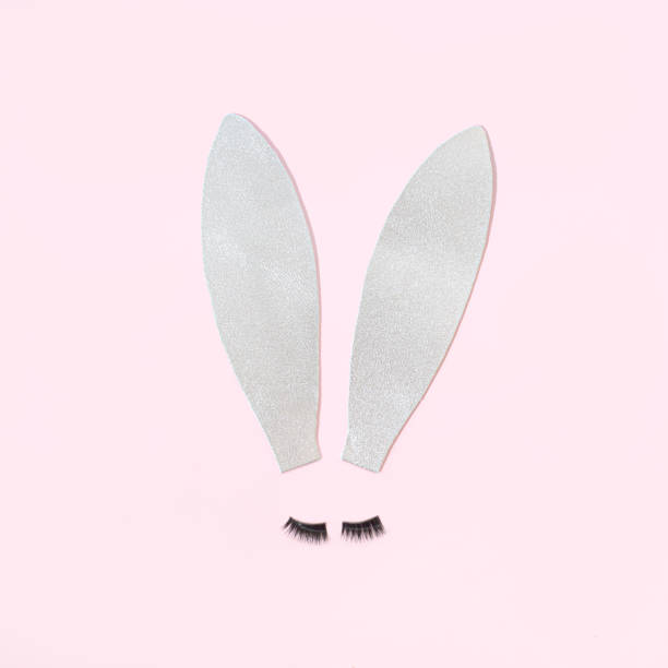 istock Easter bunny silver ears with lashes on a pastel pink background. 1386178831