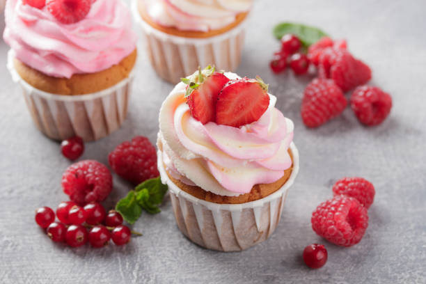istock Pink cupcakes with cream and fresh berries 1386178882