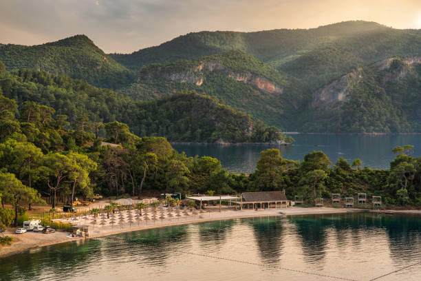 schöner sandstrand an den bergen in fethiye türkei - provinz mugla stock-fotos und bilder