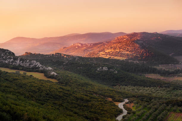 Pink sunset in the mountains in Turkey with olive trees gardens at golden hour