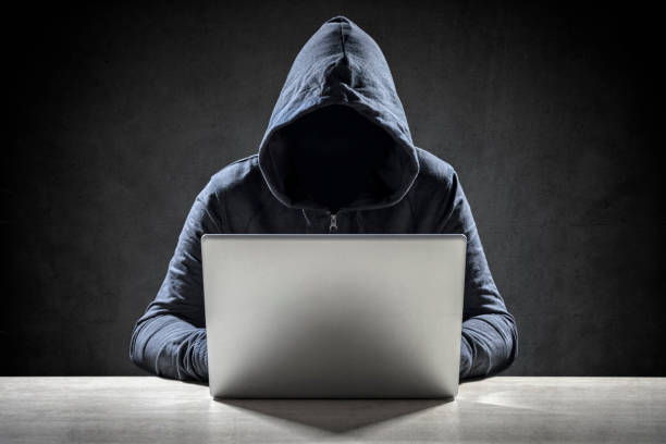 Computer hacker stealing data from a laptop Computer hacker stealing data from a laptop concept for network security, identity theft and computer crime interception stock pictures, royalty-free photos & images