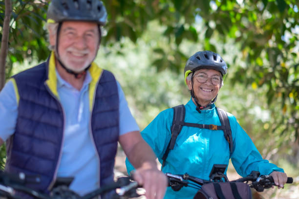 istock Active caucasian senior couple with electrobikes standing outdoors in the park. Two happy elderly people running in nature enjoying healthy lifestyle 1386186963