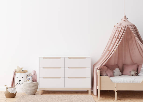 istock Empty white wall in modern child room. Mock up interior in scandinavian style. Free, copy space for your picture, poster. Bed, console, rattan basket, toys. Cozy room for kids. 3D rendering. 1386190765