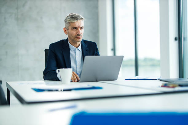 istock Pensive businessman working on laptop in the office. 1386196387