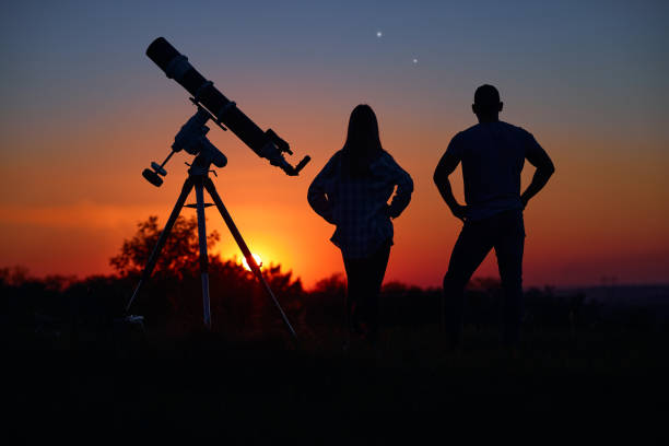 istock Couple stargazing together with a astronomical telescope. 1386197890