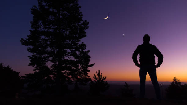 istock Man observing evening sky with stars, planets and crescent Moon. 1386197953
