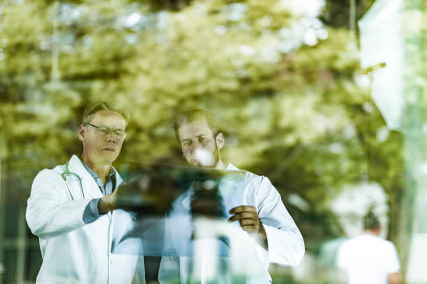 istock Two male doctors cooperating while analyzing medical scan in hospital. 1386200328