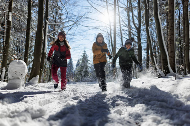 istock Happy kids running in beautiful winter forest on a sunny day 1386202700