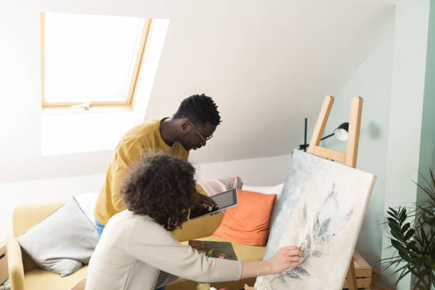 istock African man using tablet and supporting his his girlfriend-the painter 1386208383