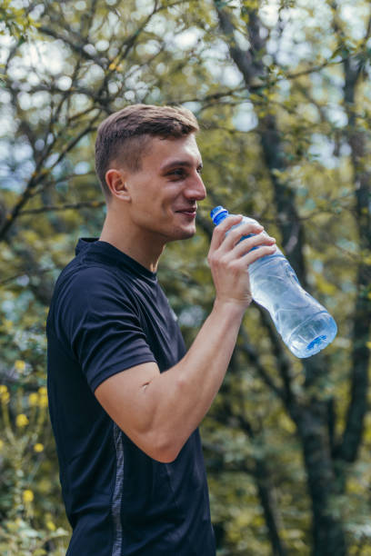 istock Male athlete drinking water, refreshing, hydrating after a long exhausting workout, run. 1386209969