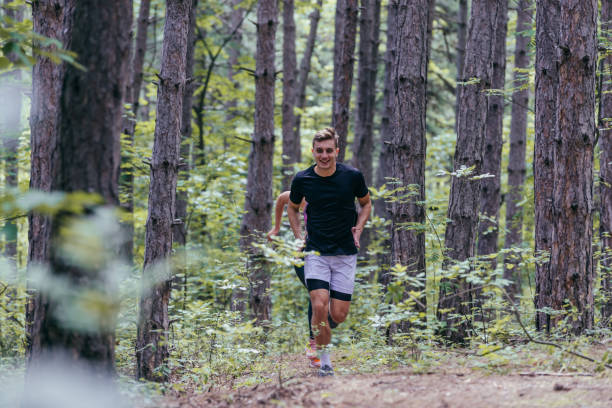 istock Strong male runner jogging for marathon on forest road 1386210143