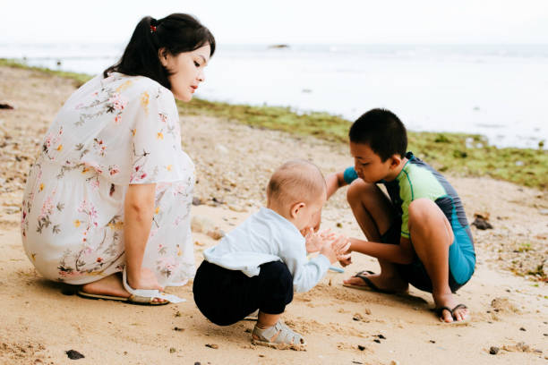 istock Mother and son on the beach playing with sand - 1386210318