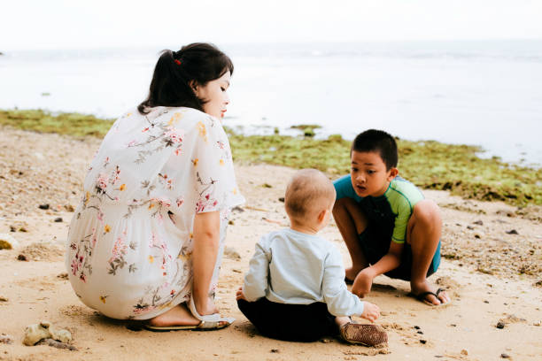 istock Mother and son on the beach playing with sand - 1386210350