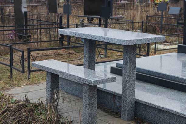 gray bench and table of stone and marble at the grave in the cemetery