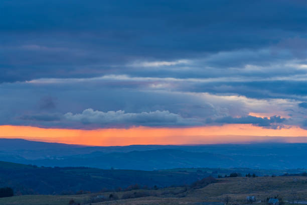 istock Colorful Rain Across Clouds During Sunset Over Hills Stormy Sky 1386217610