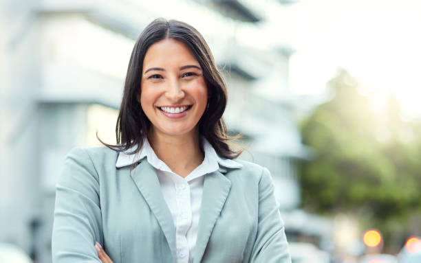 Portrait of a confident young businesswoman standing against an urban background Success starts with how you dress professional woman stock pictures, royalty-free photos & images