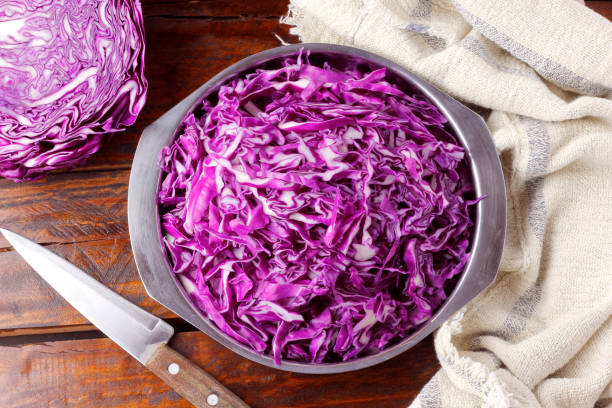 istock Raw red cabbage sliced in stainless bowl over rustic wooden table 1386219702