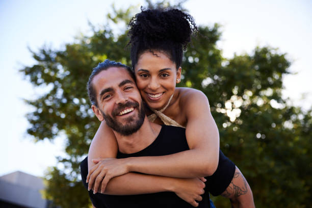 istock Laughing young couple having fun together outside in summer 1386226488