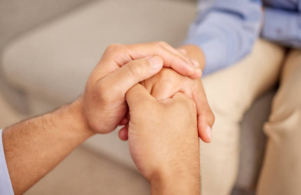 istock Shot of two unrecognizable people holding hands together inside 1386228900