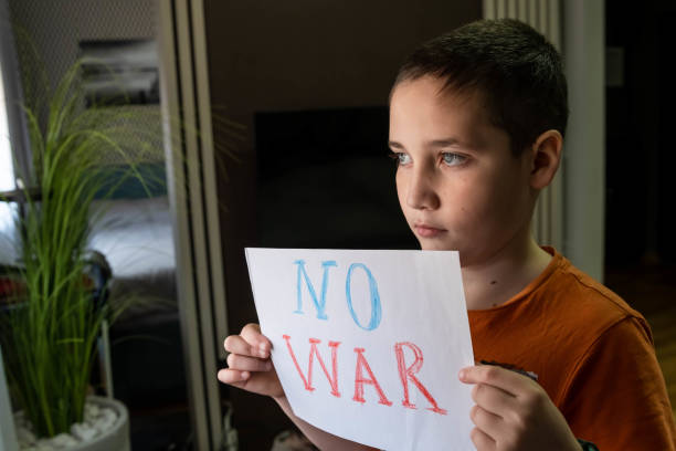 istock Slogan of peace without war. Child with message Stop War. 1386232236