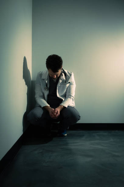 istock Tired frustrated doctor in dark hallway 1386232488