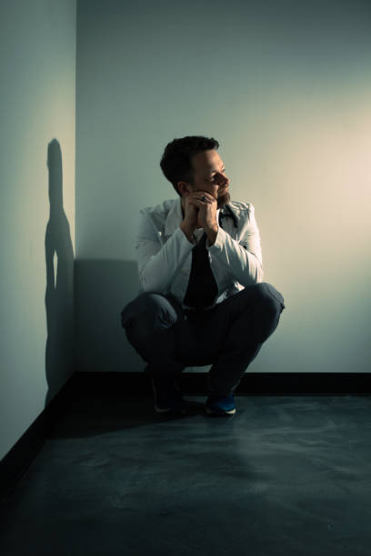 istock Tired lonely doctor in dark hallway 1386232561