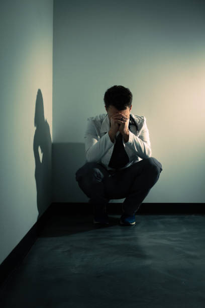 Tired lonely upset doctor in dark hallway stock photo