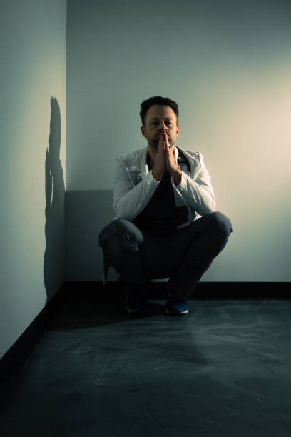 istock Tired lonely doctor in dark hallway 1386232641