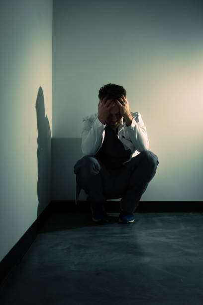 istock Tired and frustrated doctor in dark hallway 1386232680