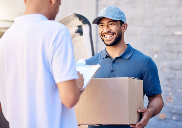 photo d’un jeune homme recevant sa livraison du courrier - livreur photos et images de collection