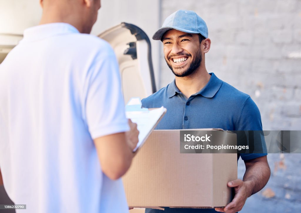 Shot of a young man receiving his delivery from the courier Customer service comes first Delivery Person Stock Photo