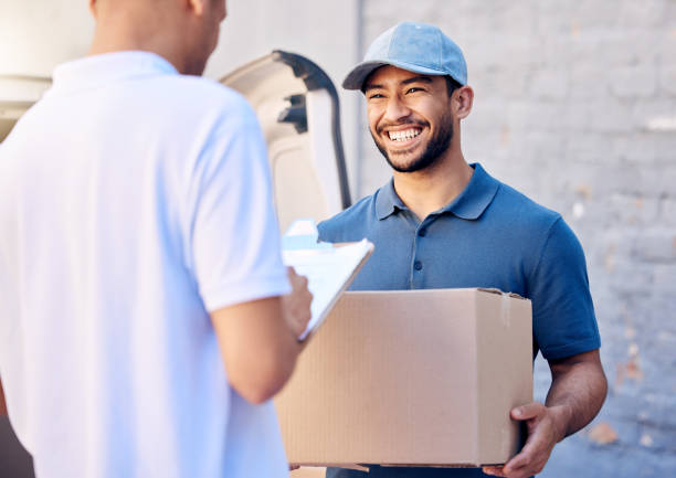 Shot of a young man receiving his delivery from the courier Customer service comes first delivery person stock pictures, royalty-free photos & images