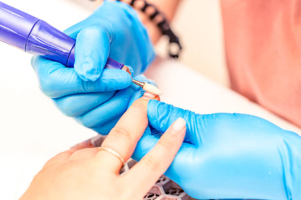 istock Manicure process. The manicure master polishes the nail using a machine. Close up manicure process 1386235659