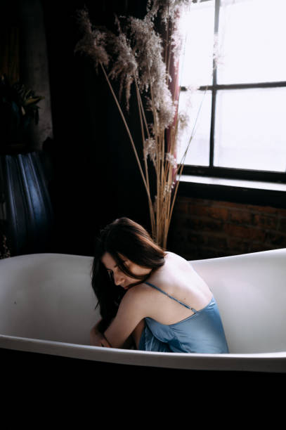 istock Young woman sitting in the bath 1386239631