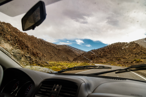 View of mountains and highway from inside a car in Salta, Argentina