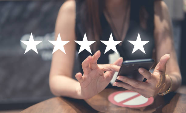 istock Customer Experience Concept, happy Business women holding the smartphone with visual screen of Excellent Smiley Face and Rating for a satisfaction survey. 1386241231