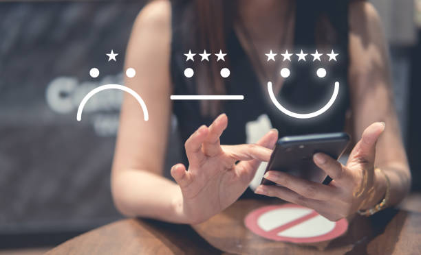 istock Customer Experience Concept, happy Business women holding the smartphone with visual screen of Excellent Smiley Face and Rating for a satisfaction survey. 1386241245