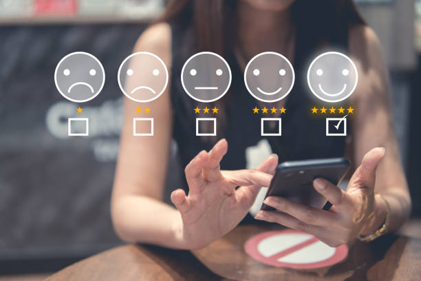 istock Customer Experience Concept, happy Business women holding the smartphone with visual screen of Excellent Smiley Face and Rating for a satisfaction survey. 1386241304