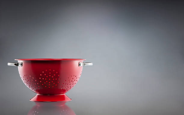 istock Stainless steel red colander on gray background 1386241350