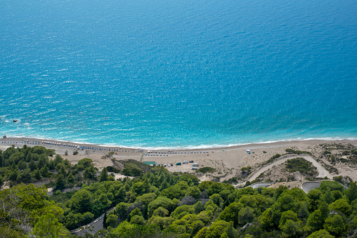 Scenic cliffs near sunny turquoise blue sea shore on a bright clear day in Gialos beach, Lefkada island, Ionian sea coast, Greece.