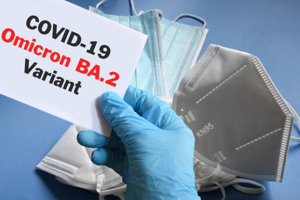istock Doctor's hand in blue glove with white paper and text Covid-19 Omicron BA.2 Variant with various protection masks on background. COVID-19 Omicron BA.2 Variant strain protection concept. 1386254131