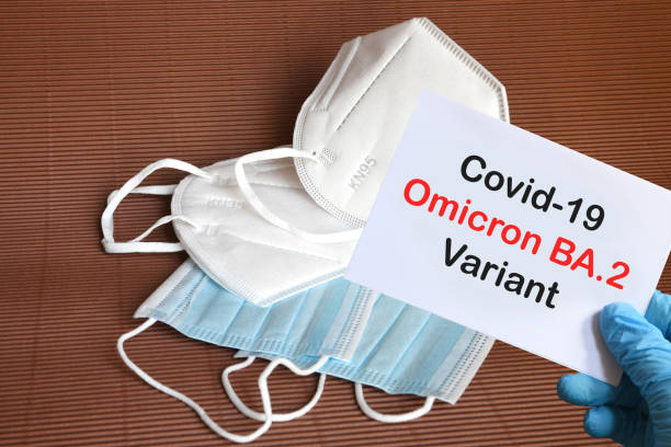 istock Doctor's hand in blue glove with white paper and text Covid-19 Omicron BA.2 Variant with various protection masks on background. COVID-19 Omicron BA.2 Variant strain protection concept. 1386254134