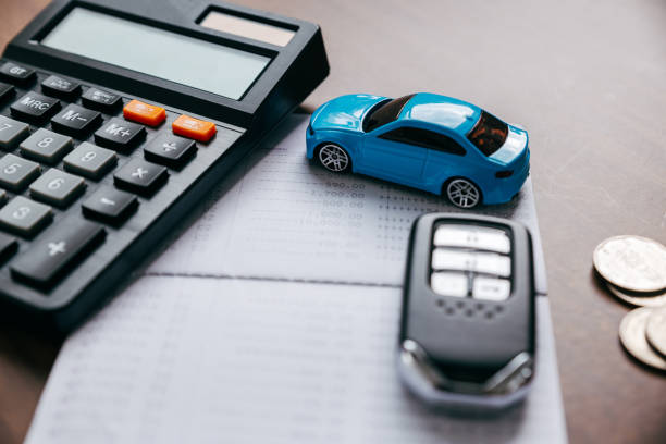 istock Car with key and calculator on bookbank. 1386255347