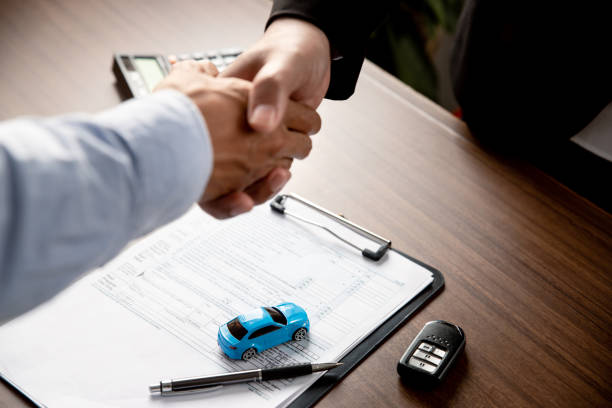 Handshake of two young man after deal to make a successful car offer at workshop. stock photo