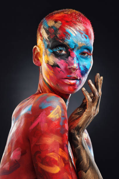 shot of an attractive young woman posing alone in the studio with paint on her face and body - beautiful confidence bizarre exoticism imagens e fotografias de stock