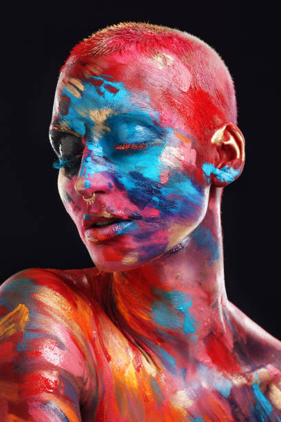 shot of an attractive young woman posing alone in the studio with paint on her face and body - beautiful confidence bizarre exoticism imagens e fotografias de stock